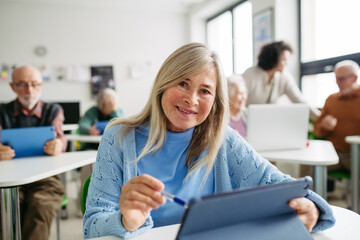 Older woman learning digital skills during course at community center.