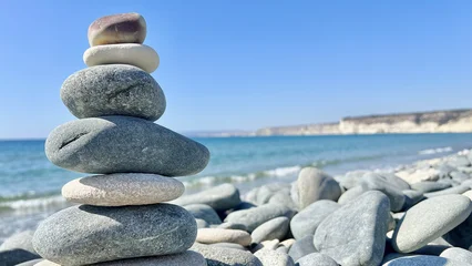 Selbstklebende Fototapeten Zen Steine Tower from Balanced stones on a peaceful beach shore of sea, ocean. Time of peace, harmony and meditation.  © M.IVA