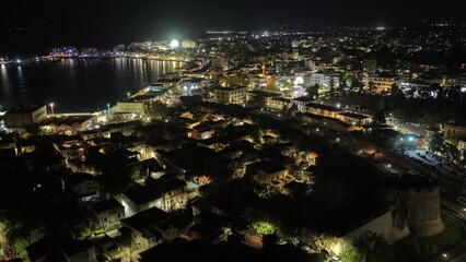 Night aerial drone view of Chios town, Greece, with illuminated streets, harbor lights and vibrant...