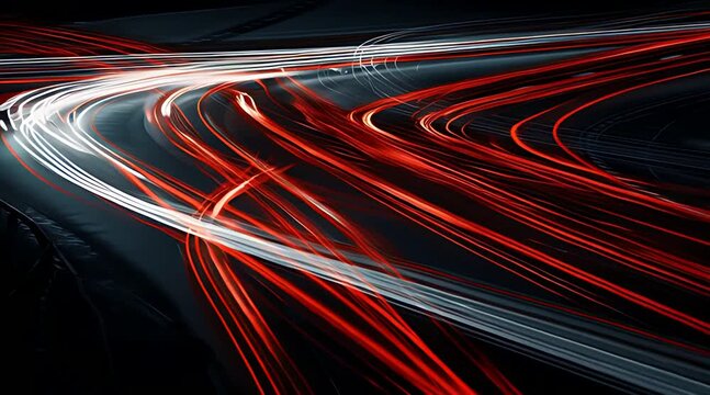 Abstract red and white light trails of fast moving traffic on a winding highway at night simulating long exposure car headlights and taillights