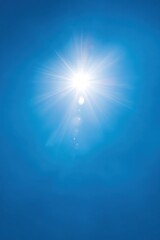 Fototapeta premium Bright sun in clear blue sky with radiant sunlight