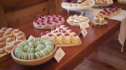 Assorted colorful desserts on a rustic wooden table, inviting sweet treats