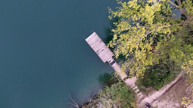 Drone Rotation Over Lago Telese Pier with Transparent Waters and Moving Trees