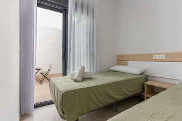 Twin bedroom with green bedding and access to private patio