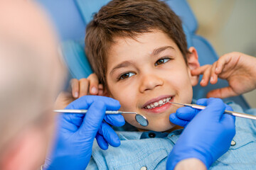 Examining a boys teeth during a dental checkup prevents cavities and promotes oral health. The procedure is gentle, quick, and vital for a confident smile