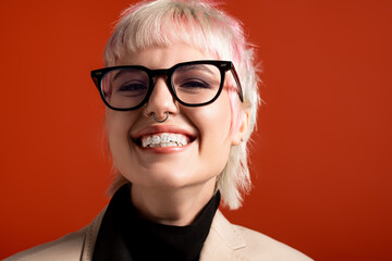 Fototapeta premium Bright smile of a young woman with unique style against a vibrant backdrop