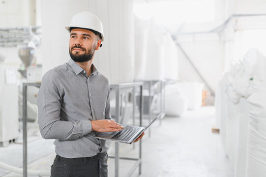Engineer using laptop and inspecting production line in food processing plant