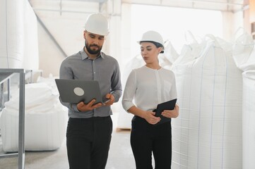 Engineers inspecting flour production in food processing plant