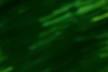 Obraz premium Abstract dappled green light streaks against a dark emerald background creating a moody
