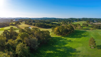 Aerial of a summer golf course showing lush greens and fairways, emphasizing landscape maintenance