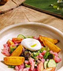 Healthy salad with poached egg and fresh vegetables served in a bowl