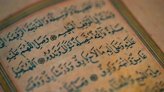 Quran close-up of an old handwritten manuscript, showing detailed Arabic calligraphy and aged paper textures.