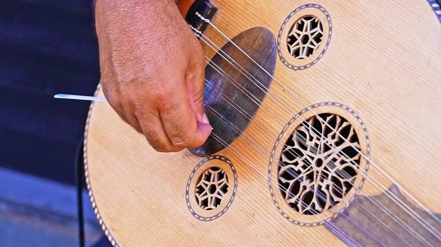 Close-up of a musician playing the saz in slow motion, highlighting hand movements, instrument details, and musical performance.