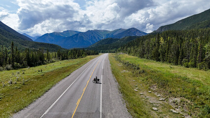 Naklejka premium Adventurous cyclist riding through stunning mountain landscape on open highway