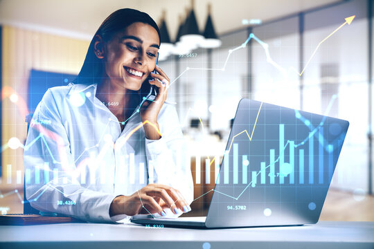 Businesswoman talking on phone and working on laptop with financial data charts overlay in modern office background. - Powered by Adobe