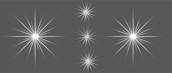 A collection of bright white starbursts and shining light flares on dark background