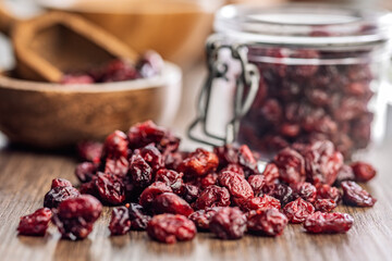 Tasty dried cranberries on wooden table.