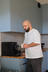 Man preparing coffee with an espresso machine in a modern home kitchen during a calm morning routine