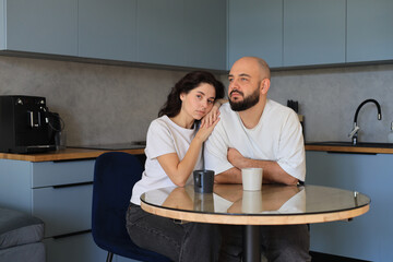 Couple sitting quietly at the kitchen table, sharing a calm moment of emotional closeness and gentle support