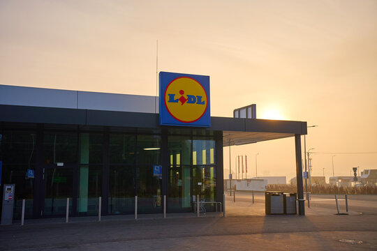 Lidl supermarket exterior with a large logo above the entrance at sunrise