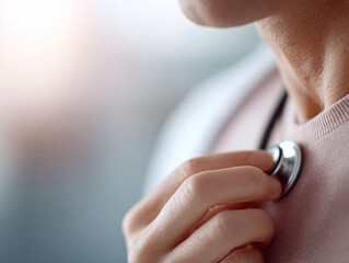 Fototapeta premium Closeup shot of a person using a stethoscope on their chest, symbolizing selfcare, health awareness, or medical examination. Soft light creates a gentle, clinical feel.