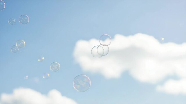 Soap bubbles floating against clear blue sky with fluffy white clouds