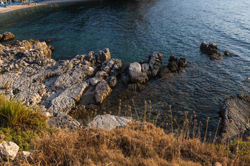 Aerial view: crystal clear turquoise ocean water and rugged rocky coast