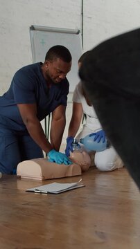 Participants enthusiastically practice CPR techniques in a well-lit classroom, focusing on a lifelike mannequin, fostering key lifesaving skills during training