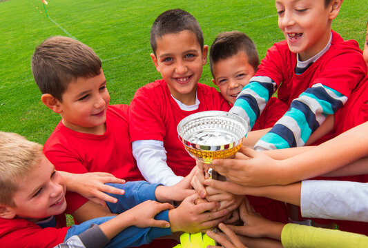 Kid`s soccer team in field celebrating the triumph