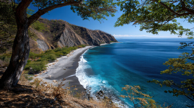 Beautiful tranquil view of secluded coast with sandy beach meeting blue sea water. serene landscape with mountain and cliff