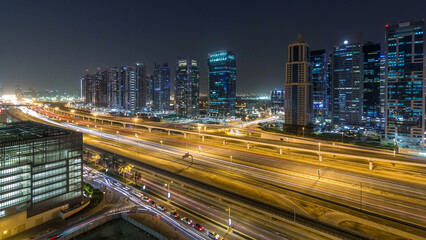 Aerial view of Jumeirah lakes towers skyscrapers day to night timelapse with traffic on sheikh zayed road.