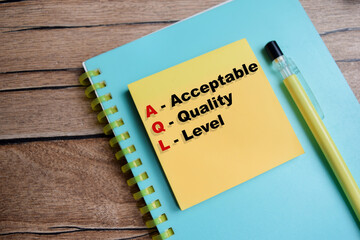 Concept of AQL - Acceptable Quality Level write on sticky notes isolated on Wooden Table.