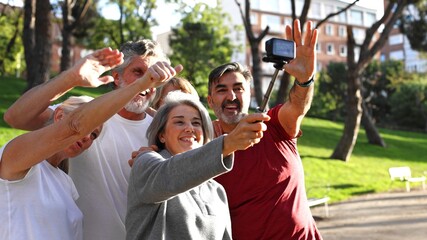 Happy senior friends taking selfie in park together