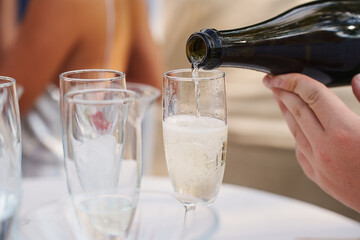 Pouring champagne at a festive outdoor gathering