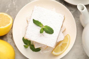 Tasty lemon bars with mint and fresh fruits on grey marble table, flat lay