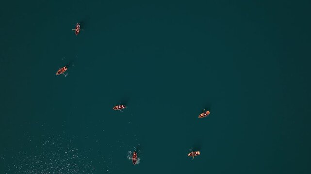 Aerial view of boats sailing on the tranquil, deep blue waters of Lake Misurina, creating a striking contrast, Misurina, Veneto, italy.