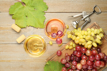 Tasty rose and white wine, grapes, corkscrew on wooden table, flat lay
