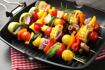 Grill pan with tasty vegetables on grey table, closeup