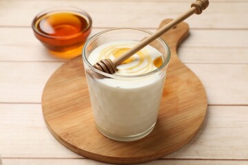Delicious Greek yogurt with honey served on white wooden table, closeup