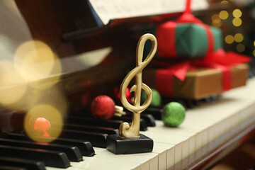 Christmas atmosphere. Golden treble clef on piano, closeup. Bokeh effect