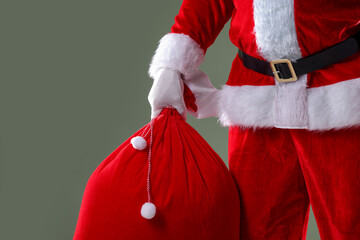 Santa Claus holding sack on grey background, closeup with space for text. Merry Christmas and Happy...