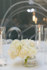 Elegant white flowers and soft candlelight create a tranquil dining experience for guests