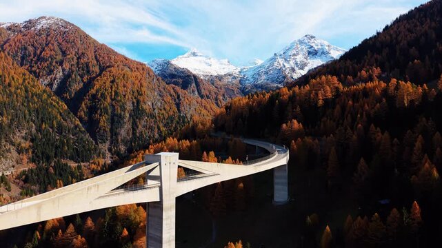 Aerial view of the Ganter Bridge cutting across the mountainous terrain with the snow-capped mountains in the background, Ried-Brig, Wallis, Switzerland.