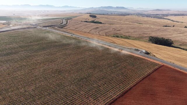 Aerial view of fields contrasting with a road cutting through the landscape, creating a visual tapestry of colors, Malmesbury, Western Cape, South Africa.