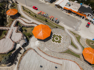 Aerial view of octagonal structures with orange roofs stand out against the stone pathways, Quilotoa lake, Cotopaxi province, Ecuador.