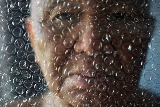 Senior man with bubble wrap covering his face