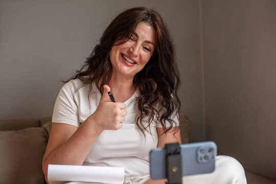 Woman blogging from home with smartphone
