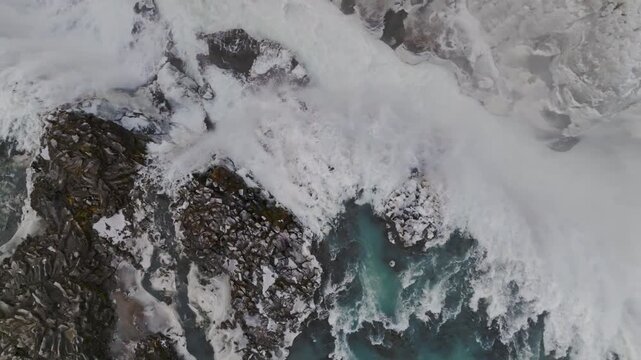 Aerial view of the mighty Gullfoss waterfall cascading over rugged terrain into the turquoise waters below, Hrunamannahreppur, Iceland.