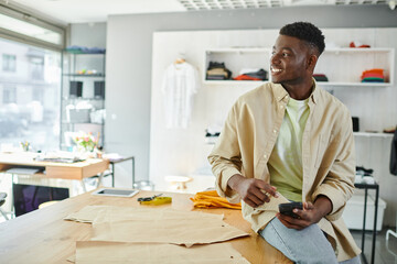Young entrepreneur at his print studio smiling while working on a project