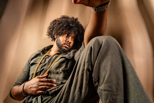 Pensive man with afro in stylish studio setting